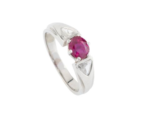 A ruby and diamond three stone ring, the oval mixed-cut ruby claw set between two triangular-cut diamonds, white precious met