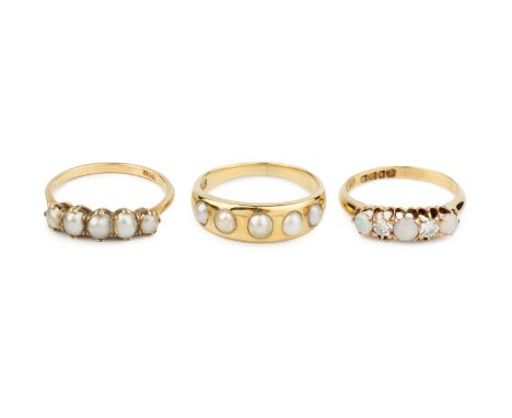 An opal and diamond five stone ring, 18ct gold mounted, and two half pearl five stone rings, each stamped '18C', (half pearls