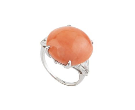A coral and diamond dress ring, the circular coral cabochon claw set between shoulders of baguette, triangular and square ste