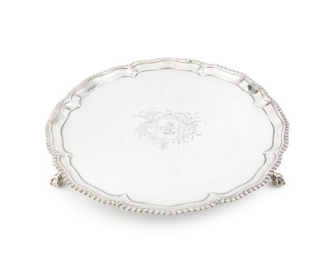 An early George III silver salver, with shaped and gadrooned border, on claw and ball feet, engraved foliate cartouche and cr