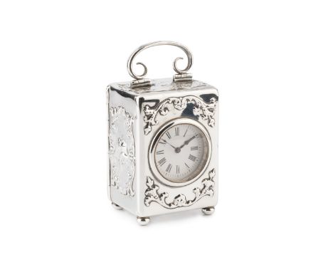 An Edwardian silver carriage timepiece, having circular white enamel dial, the rectangular case embossed with winged cherubs 