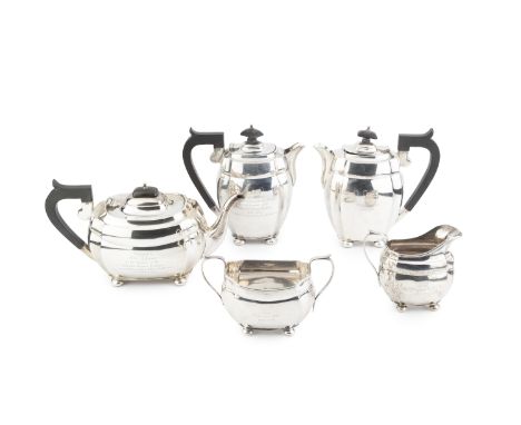 A George V silver five piece tea set, consisting of a teapot, two hot water jugs, a milk jug, and a sugar basin, with ebonise