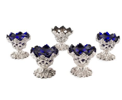 A set of five early Victorian silver pedestal salts, in the Gothic style, the openwork sides embossed and engraved with folia