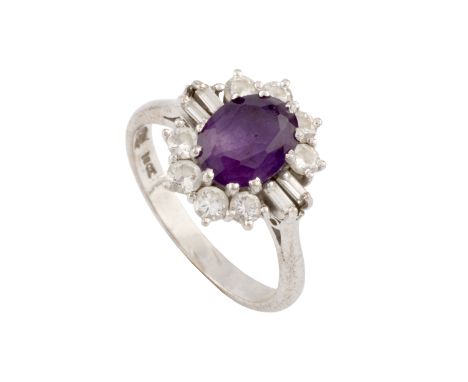 An amethyst and diamond cluster ring, the oval mixed-cut amethyst claw set within a border of round brilliant and baguette-cu