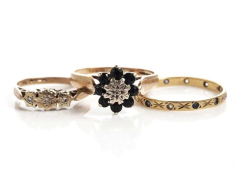 A sapphire and diamond flower cluster ring, in 9ct yellow gold, size P, 2.6g gross; a diamond three stone ring, in 9ct yellow