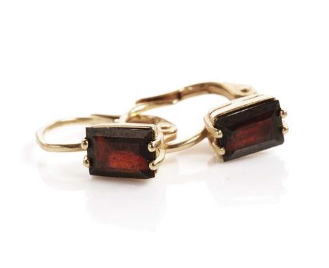 A pair of garnet earrings, each set with a step cut garnet, in 14ct yellow gold, 15mm high, 2.7g gross.