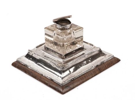 An Edwardian silver mounted inkstand, by Henry Matthews, Birmingham 1907, the square form glass inkwell with later 1920s bras
