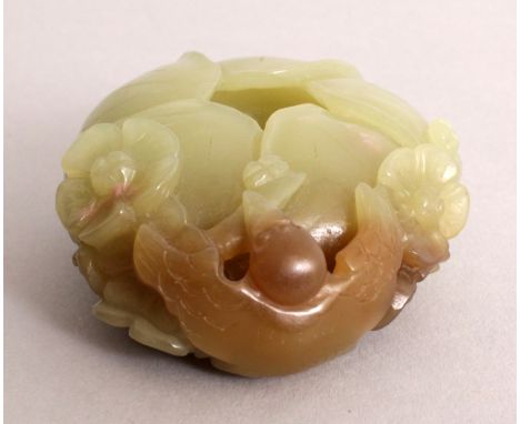 A SMALL CELADON JADE BUD FORM BRUSHWASHER, the side decorated in high relief with a tengu and blossoms, the stone with russet