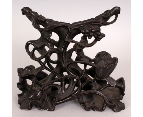 A 19TH/20TH CENTURY CHINESE CARVED & PIERCED HARDWOOD LOTUS STAND, intended for displaying a circular jade or marble disc, 7.