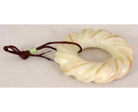 A 20TH CENTURY CHINESE JADE BI DISC, of incised spiral form to the rim, with attached cord and hardstone bead, 2.1in diameter