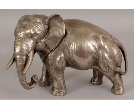 A 20TH CENTURY JAPANESE SILVERED METAL MODEL OF AN ELEPHANT, 8.25in long & 5.6in high.
