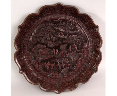 A GOOD 19TH CENTURY CHINESE RED CINNABAR LACQUER DISH, with an octofoil barbed edge rim, the interior carved with a river lan