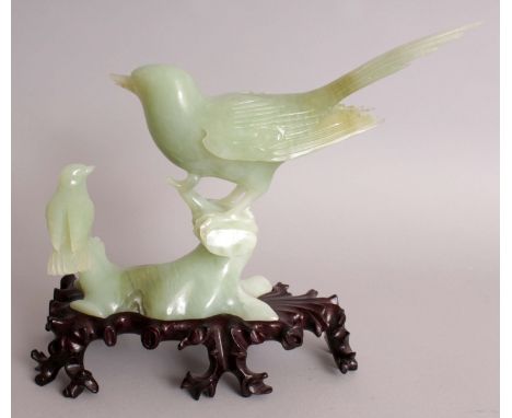 A 20TH CENTURY CHINESE CELADON GREEN JADE CARVING OF TWO BIRDS PERCHED ON ROCKWORK, together with a fitted wood stand and als