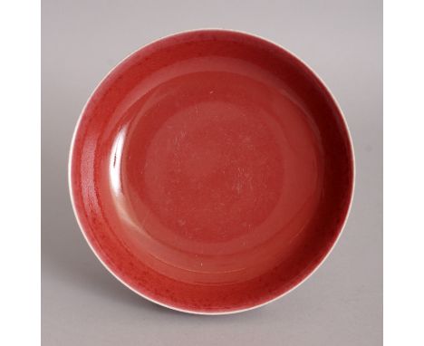 A CHINESE COPPER RED PORCELAIN SAUCER DISH, the base with a Qianlong seal mark, 6in diameter.