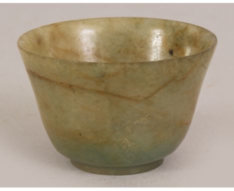 AN UNUSUAL SMALL CHINESE JADE FINGER BOWL, the predominantly green stone with russet inclusions, the base incised with a four