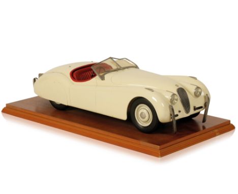 SCALE MODEL OF A JAGUAR XK120 in cream with a red interior, license number AGM 973, on a wooden base, 60cm x 30cm (base)