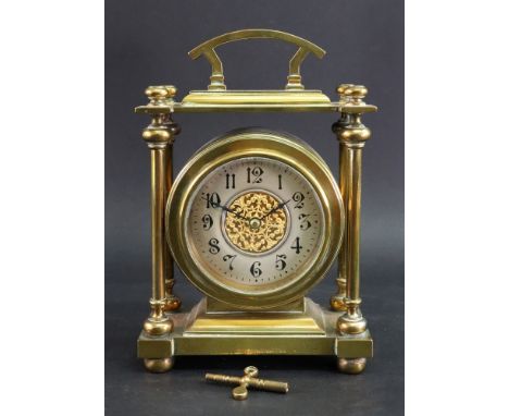 A late Victorian brass cased mantel timepiece, the pillared rectangular case with a drum cased movement, silvered chapter rin