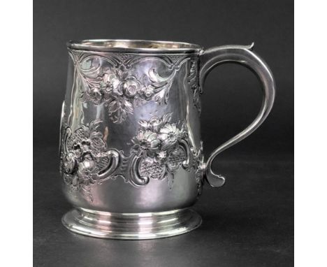 A George II silver mug, James Manners, London 1734, later embossed with flowers, leaves, scrolls and scale work around a cart