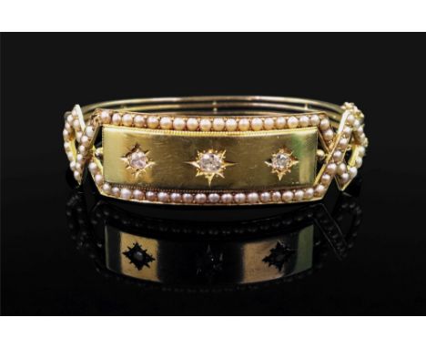 A yellow precious metal, diamond and seed pearl set hinged bangle of plaque design, set with three cushion-cut diamonds, claw