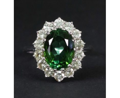 A tourmaline and diamond set dress ring of cluster design, the oval-cut tourmaline approximately 4ct, claw set in a surround 