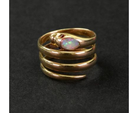 An 18ct gold, opal and ruby ring, designed in the form of a coiled serpent, set with an oval opal to the head and ruby eyes, 