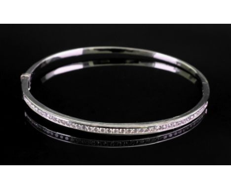 An 18ct white gold diamond set hinged bangle, set with circular-cut diamonds, 11g gross.