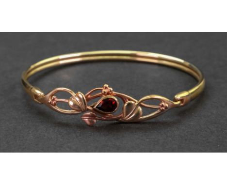 A Welsh Clogau 9ct gold and garnet-set bangle, the pear-cut garnet set in a leaf design, Welsh dragon mark, 11.6g gross, case
