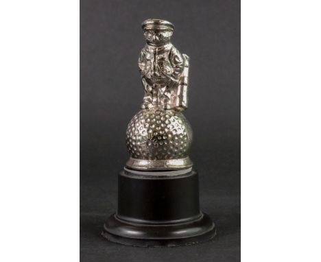 A Dunlop Caddy Man, a silvered figure of a man with golf clubs, stood on an oversize golfball, detailed 'Dunlop 31', 9cm high
