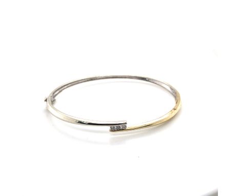 A 9ct HALLMARKED YELLOW AND WHITE GOLD HINGED BANGLE WITH THREE CHANNEL SET BRILLIANT CUT DIAMONDS, APPROX 0.15pts. WEIGHT 8.