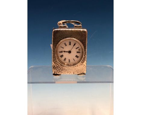 A HALLMARKED SILVER CASED SMALL DRESSING TABLE CLOCK WITH HAMMERED FINISH (PROBABLY BIRMINGHAM 1909) THE WHITE ENAMEL DIAL WI