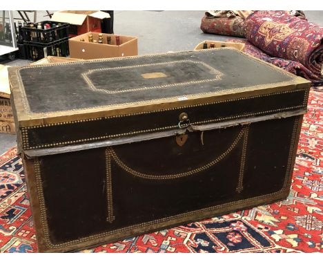 A BRASS CLOSE NAILED BLACK LEATHER COVERED CAMPHOR WOOD TRUNK WITH BRASS EDGING AND WITH TWO HANDLES.   W 108 x D 59 x H 56cm