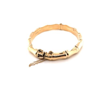 A 9ct HALLMARKED YELLOW GOLD BAMBOO STYLE HINGED BANGLE, COMPLETE WITH SAFETY CHAIN. DATED 1958, CHESTER. WEIGHT 11.69grms. 