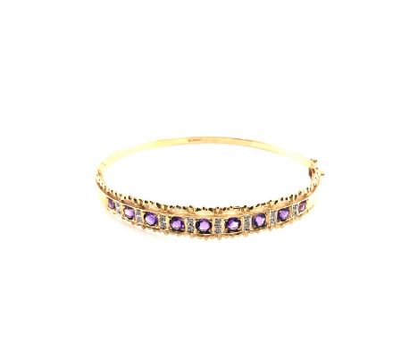 A HALLMARKED 9ct GOLD NINE STONE AMETHYST HINGED BANGLE WITH FIGURE EIGHT SAFETY CLASP. WEIGHT 11.80grms