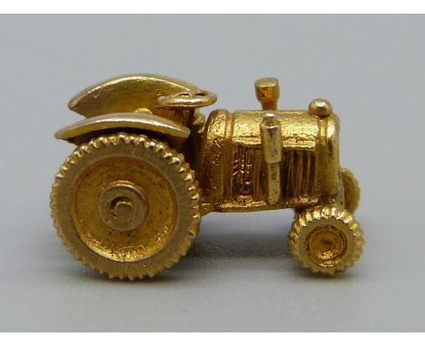 A hallmarked 9ct gold tractor charm with moveable wheels, 2.8g 