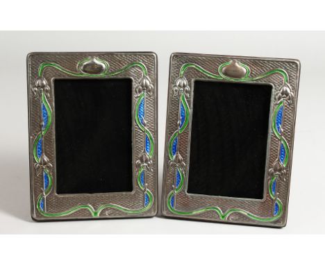 A PAIR OF SILVER AND BLUE ENAMEL ART NOUVEAU DESIGN PHOTOGRAPH FRAMES. 8ins x 5ins.