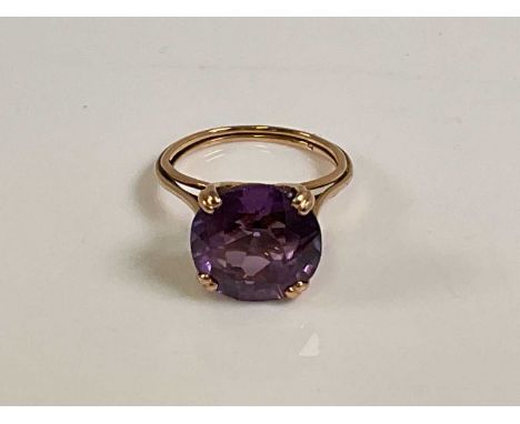 A yellow metal dress ring, with large four claw set amethyst coloured stone, hallmarks indistinct, size N 1/2, approx 4.9g.