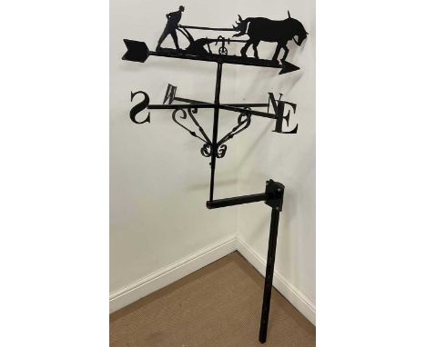 A metalwork weather vane, with top featuring a horse drawn ploughing scene, height 145cm x N S E W diameter 70cm.