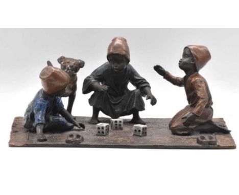 IN THE MANNER OF FRANZ XAVER BERGMANN; an Austrian cold painted bronze figure group of three boys playing dice on a carpet, s