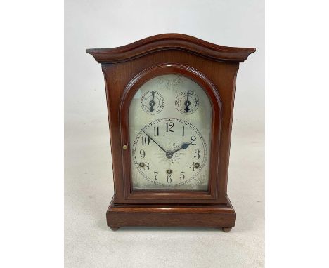 A mahogany mantel clock, with Windsor chimes and arched silvered dial, 37 x 26 x 16cm, with key.