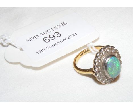 An opal and diamond ring in gold setting