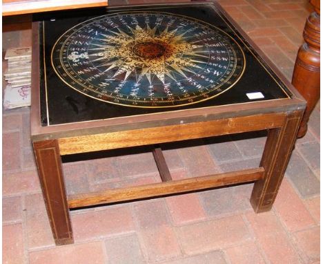 A square coffee table with compass pictures below glass - 61cms square