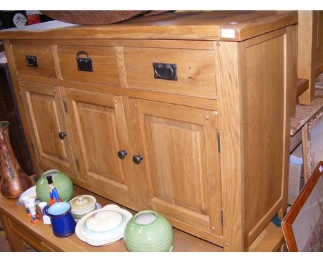 A contemporary light oak sideboard, comprising three drawers and three cupboards - width 135cm 