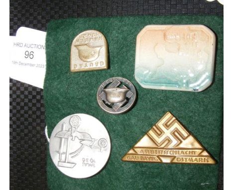 Four metal and one ceramic German lapel badges 