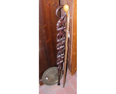 A carved wooden walking stick and one other, together with Middle Eastern brass plate 