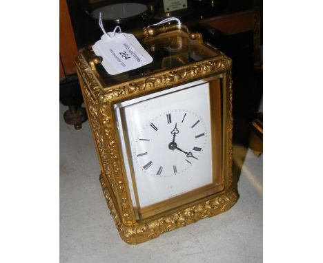 A decorative French carriage clock - the enamel dial marked Lucien Paris, having pierced gilt case and visible escapement - 1