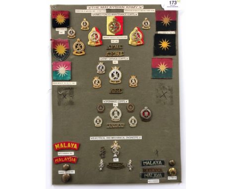 Malaysian Army 41 items of insignia.  Board with good display of metal and cloth badges and buttons including Service Corps, 