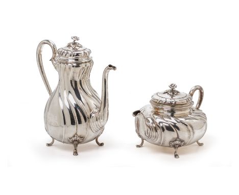 A DANISH SILVER COFFEE POT AND TEAPOT
Michelsen, Copenhagen, 1905
Of wrythen form with foliate finial and on foliate rococo f