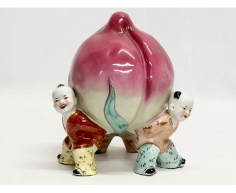 A Chinese ceramic figure of 3 children and peach. 18x25cm