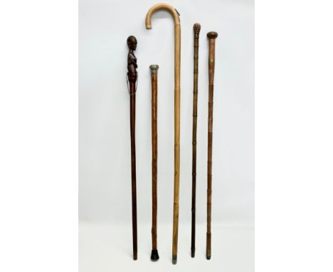 A collection of vintage walking sticks. Induding a horse measuring stick.
