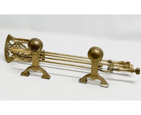 A brass companion set. Fire andirons and tools.